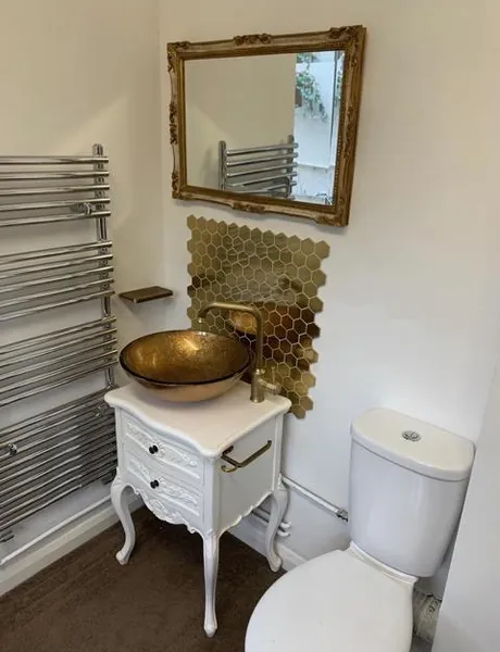 Cloakroom with vintage-style vanity, gold vessel basin and heated towel rail – cloakroom fitting for homes in Southsea