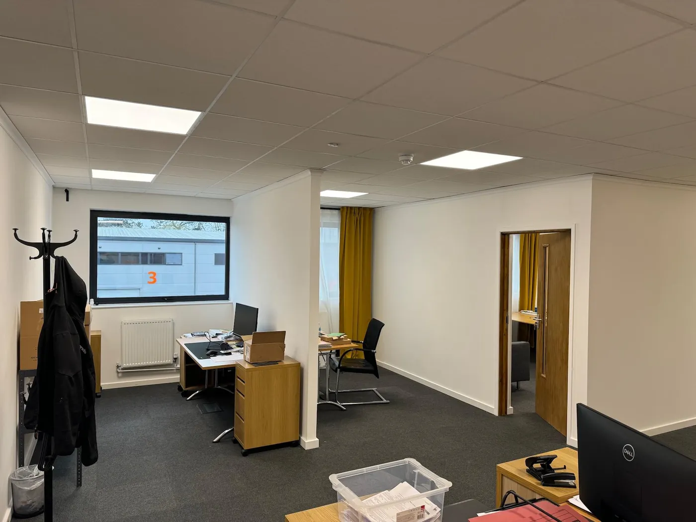 Refurbished open-plan office with ceiling tiles and LED panels, typical of commercial work by our builders in Fareham